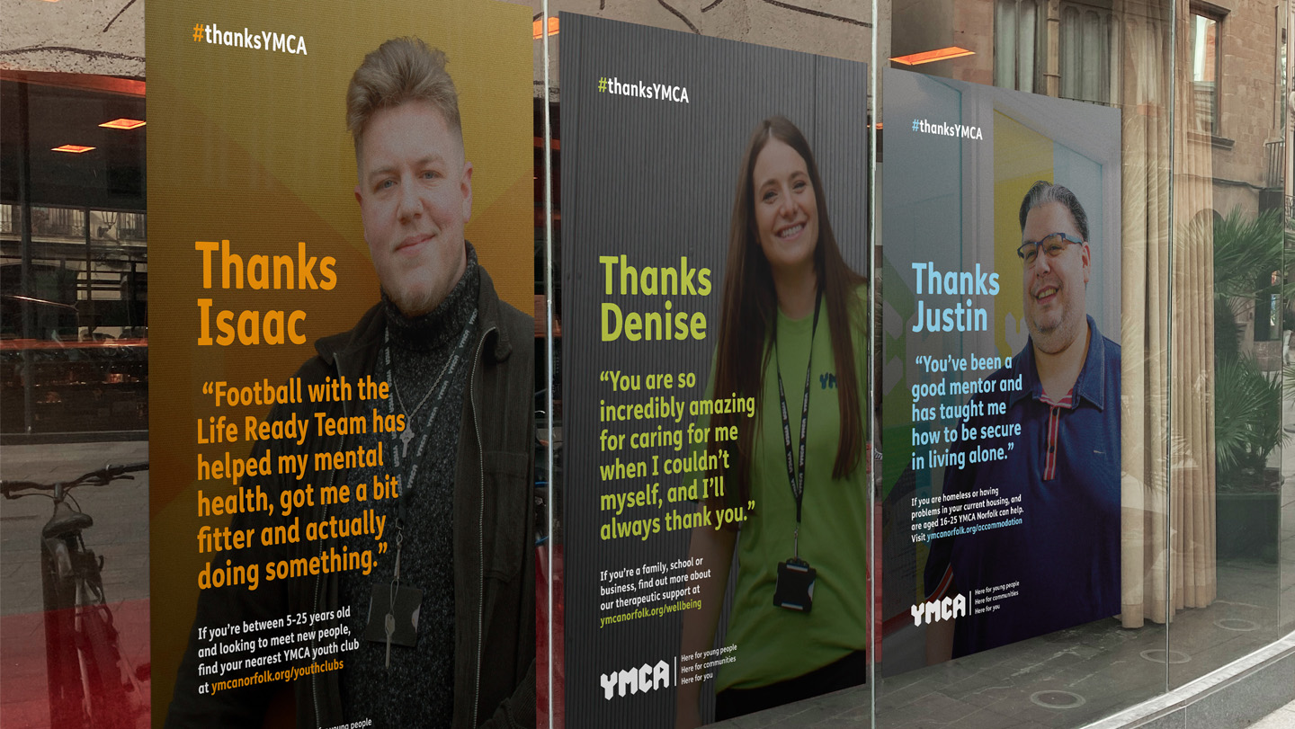 Three YMCA posters in a window
